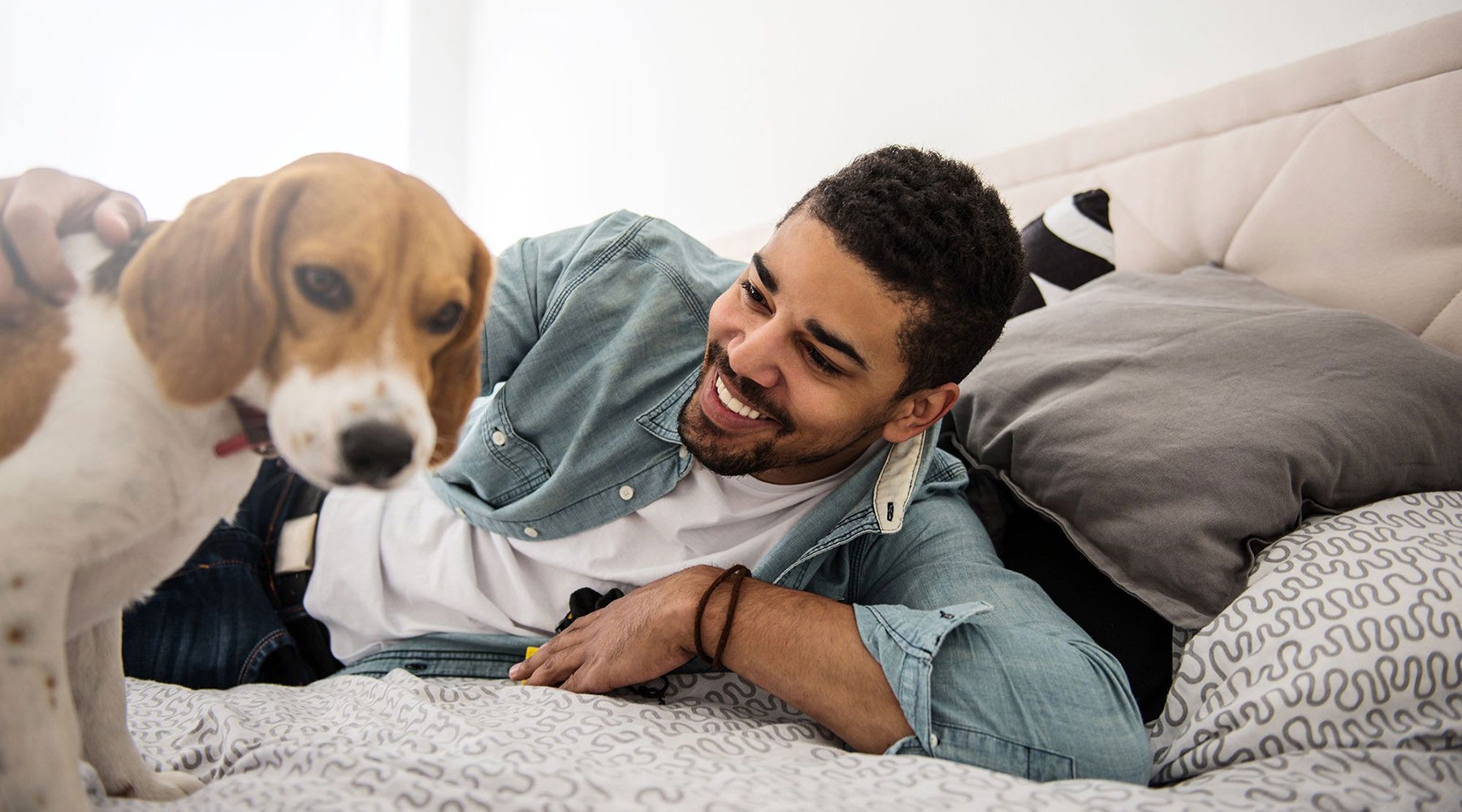 man laying on bed with dog