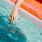woman dangles her hand in the pool as she floats in an inflatable vessel